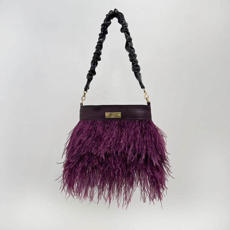 Purple feathered handbag with a chocolate brown handle on a white background