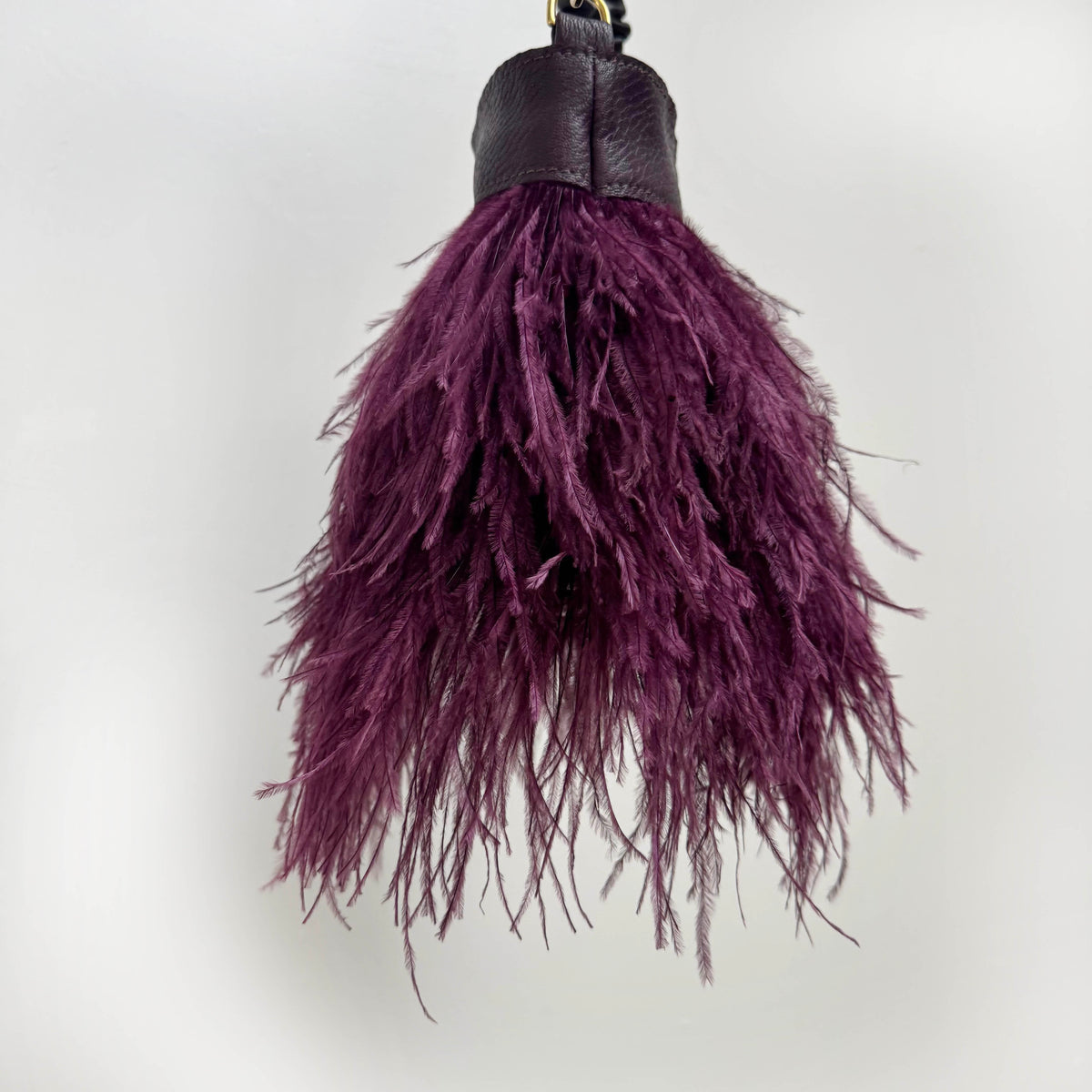 Purple feathered leather shoulder bag on a white background